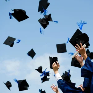 A group of people that are throwing their graduation hats in the air.