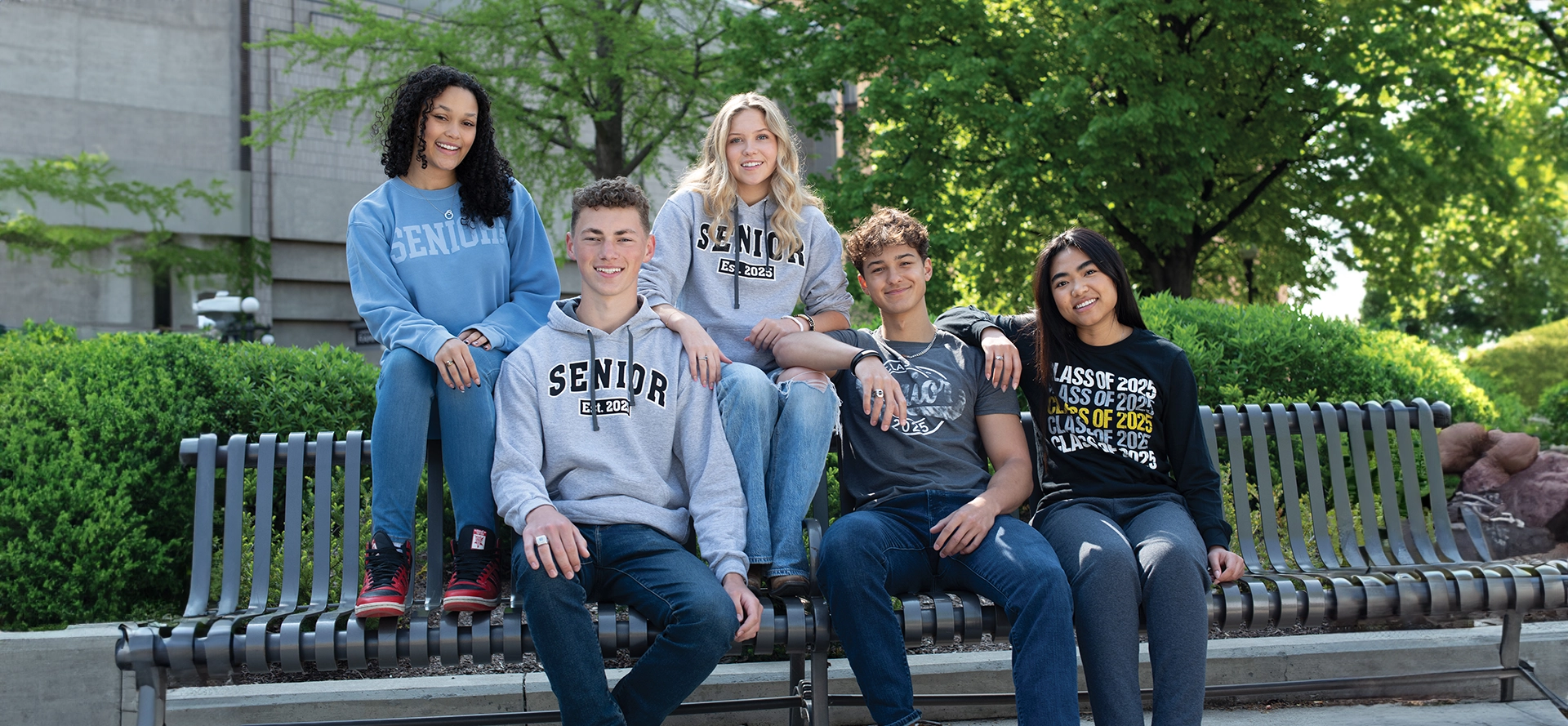 A group of people sitting on top of a bench.