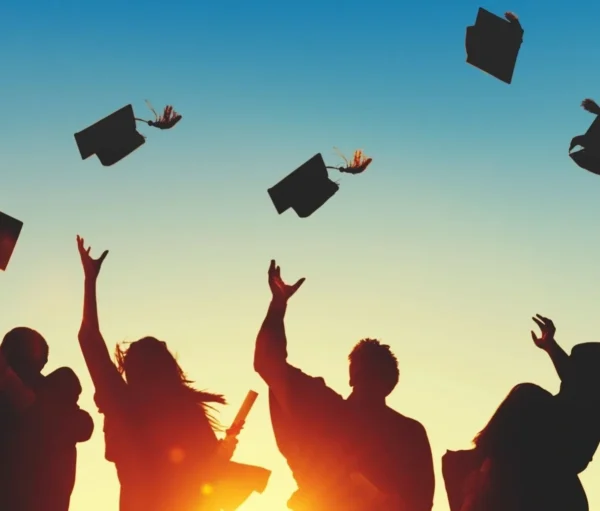 A group of people throwing their caps in the air.