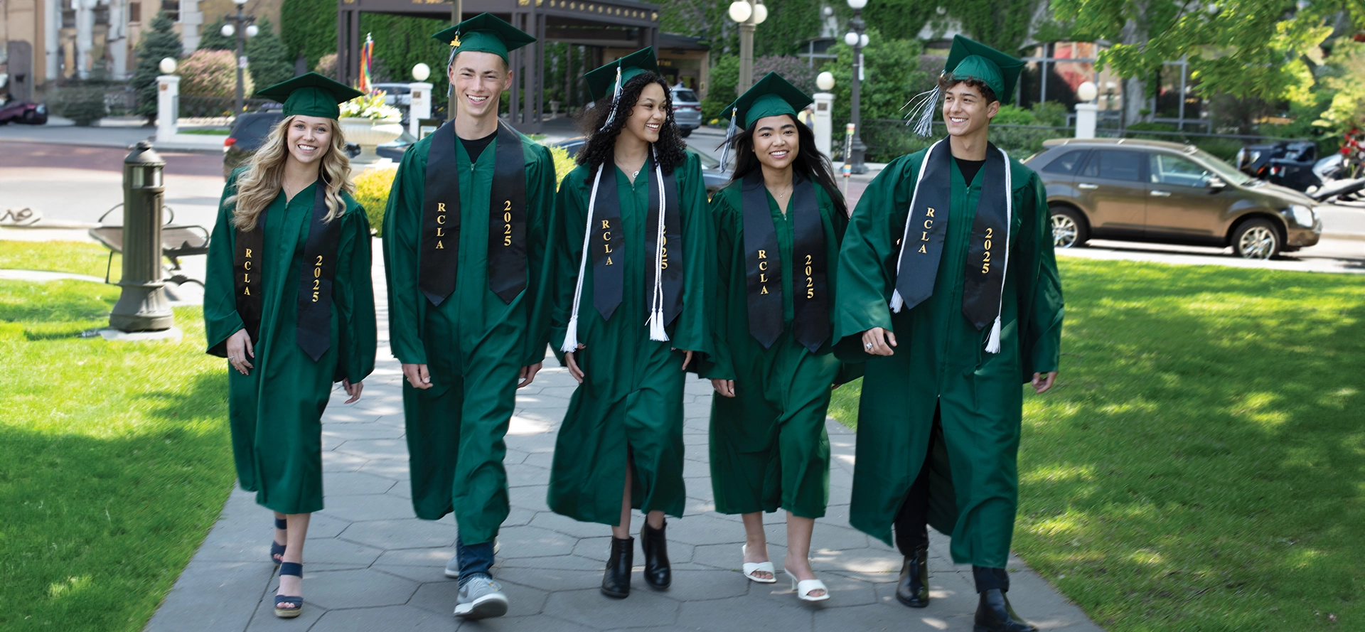 A group of people in green graduation gowns.