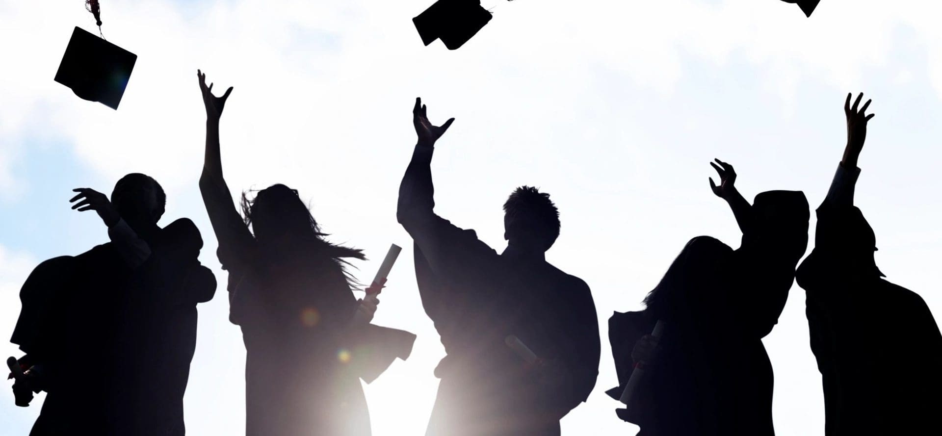 A group of people throwing their graduation caps in the air.