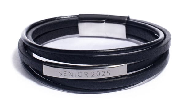 A black leather bracelet with silver lettering.